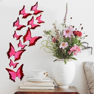 3D glowing butterfly wall stickers with pink glitter on white wall near flower vase