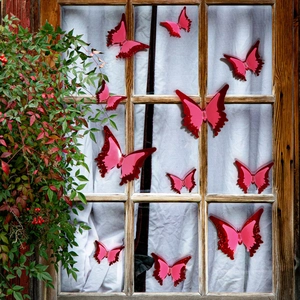 Detailed view of 3D luminous butterflies with glitter on vintage wooden window