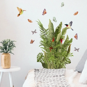 Détail de stickers muraux plantes tropicales avec oiseaux sur un mur blanc de chambre à coucher