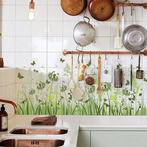 Detail of green dandelion and butterfly wall stickers applied on kitchen tile walls