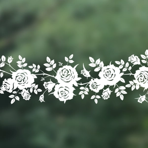 Detail of white rose vine static window stickers showing floral pattern on green background