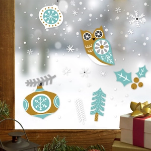 Detail showing static cling window decals with owls and snowflakes on a snowy background