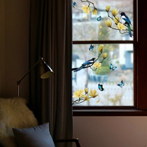Detail of static glass stickers featuring yellow magnolias, birds and blue butterflies