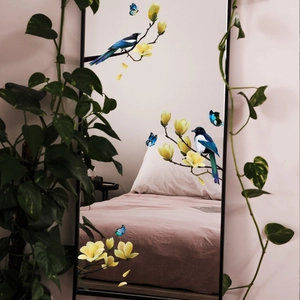 Detail of static glass stickers with bird, butterfly, and yellow flower branches on mirror