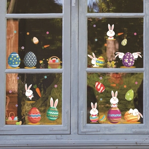 Stickers de Pâques avec lapins et œufs colorés sur une vitre avec un cadre en bois