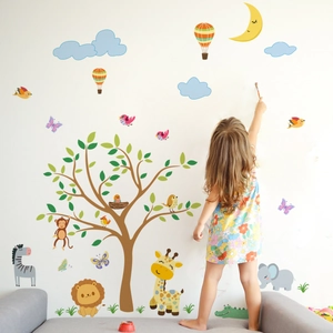 Detail of cartoon forest animals and tree wall stickers in a cozy nursery room setting