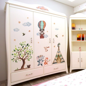 Detail of cartoon elephant and hot air balloon decals on a white three-door kids wardrobe