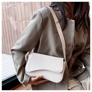 Close-up of white crocodile pattern crossbody bag showing texture and magnetic flap closure