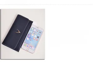 Size comparison of long black leather wallet with golden deer logo next to a phone