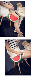 Detail view of a creative watermelon crossbody bag with a gold chain strap and charm