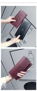 Detail of elegant leather long wallets with deer emblem in burgundy and black colors