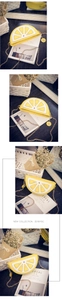 Detail of lemon-shaped crossbody bag with gold chain strap and daisy flower charm