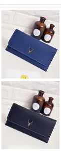 Detail of vintage long wallets featuring metal deer emblem and contrast stitching trim