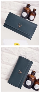 Detail of forest green long wallet with textured faux leather and bronze deer head emblem