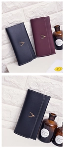 Detail of vintage long wallet for women with deer metal ornament and white stitching