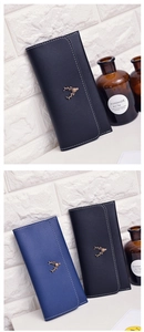 Detail of deer logo and stitching on long slim faux leather wallets in navy and black
