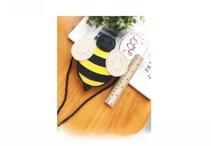 Detail showing honey bee shoulder bag height measuring 12cm with a wooden ruler