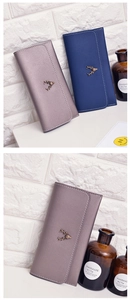 Detail of long leather wallets with metal deer logo and stylish contrast stitching