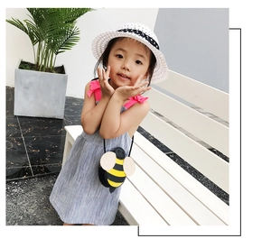 Girl wearing cute bee-shaped mini crossbody bag with yellow and black stripes