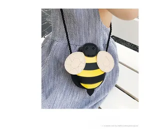 Detail of cute bee-shaped kids crossbody bag with leather stitching and woven strap