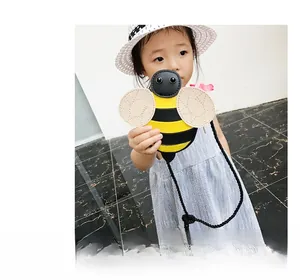 Detail of cute yellow bee crossbody bag for kids with black stripes and PU leather texture