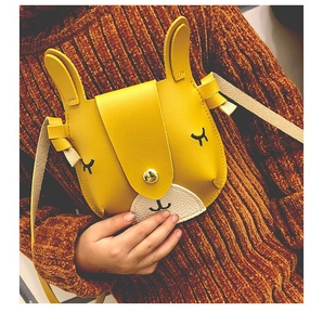Close-up of cute yellow rabbit-shaped PU leather crossbody bag for kids with gold buckle