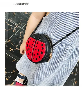 Detailed close-up of a cute red ladybug crossbody bag with black polka dots for children
