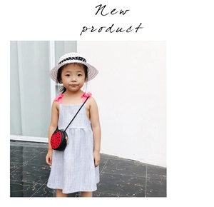Outdoor view of child summer dress with pink bow straps and a cute ladybug crossbody bag