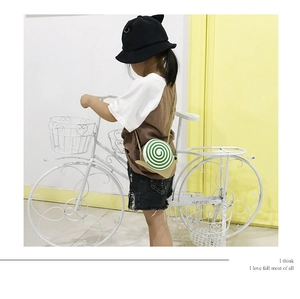 Detail of snail-shaped kids crossbody bag with green spiral on beige and gold chain