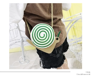 Close-up of a cute snail-shaped crossbody bag with a spiral shell and golden chain