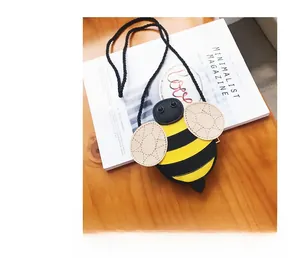 Detail of bee shaped kids crossbody bag showing yellow stripes and PU leather texture