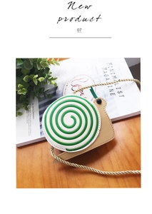 Detail showing spiral snail-shaped kids crossbody bag on a wooden table with green leaves