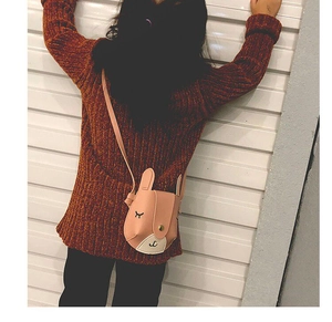Close-up of pink bunny-shaped crossbody bag with long ears on a child model's shoulder