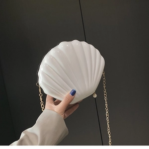 Glossy white shell-shaped shoulder bag with gold chain and pearl charm detail