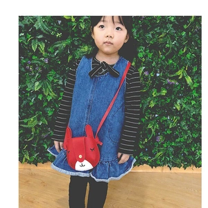 Close-up of red rabbit-shaped children bag with 3D ears and golden button closure