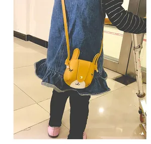 Detail of yellow rabbit crossbody bag with long ears and cute stitched facial features