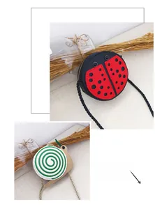 Detail of red ladybug and green snail crossbody bags with woven shoulder straps for kids