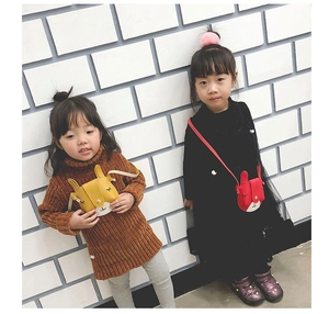 Detail of cute rabbit-shaped mini shoulder bags in yellow and red for young girls