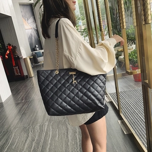 Sac bandoulière matelassé noir avec chaîne dorée et pendentif cerf sur mannequin