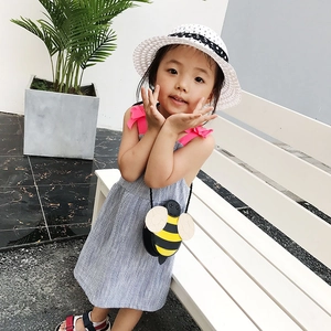 Cute cartoon bee crossbody bag for kids styled with summer dress and straw hat outdoors