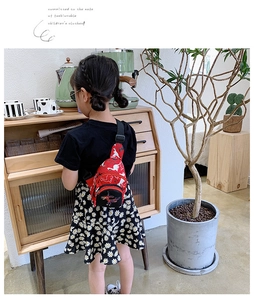 Enfant portant sac banane rouge dinosaure vue de dos et bandoulière noire réglable