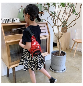 Détail de sac banane rouge pour enfant avec broderie dinosaure et sangle