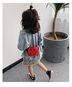 Rear view of a red mini canvas crossbody bag for children on a girl model