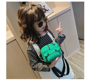 Detail of bright green canvas crossbody bag for kids featuring a sturdy zipper and strap