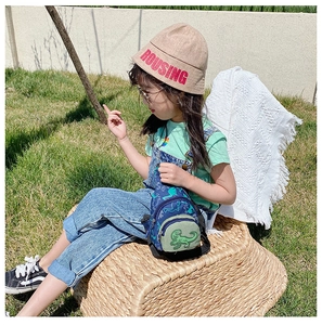 Sac de poitrine pour enfants avec motif dinosaure bleu présenté en plein air