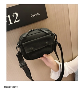 Detail of black canvas shoulder bag for kids with double zippers and metal snap button