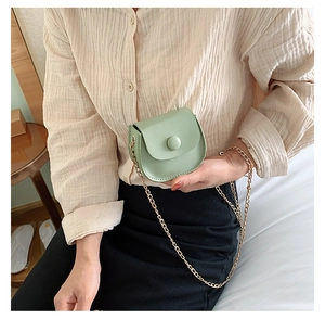 Detail of mint green mini round chain bag for girls showing the stylish metal clasp