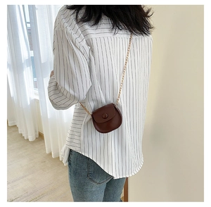 Mini semi-circular crossbody bag in dark brown with gold chain strap on model