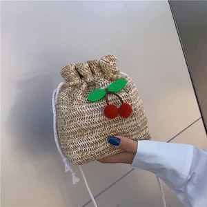 Secchiello in paglia beige con pompon a ciliegia rossi e spalline bianche intrecciate