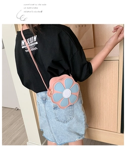 Detail of pink flower-shaped crossbody bag with blue petals on a child model back